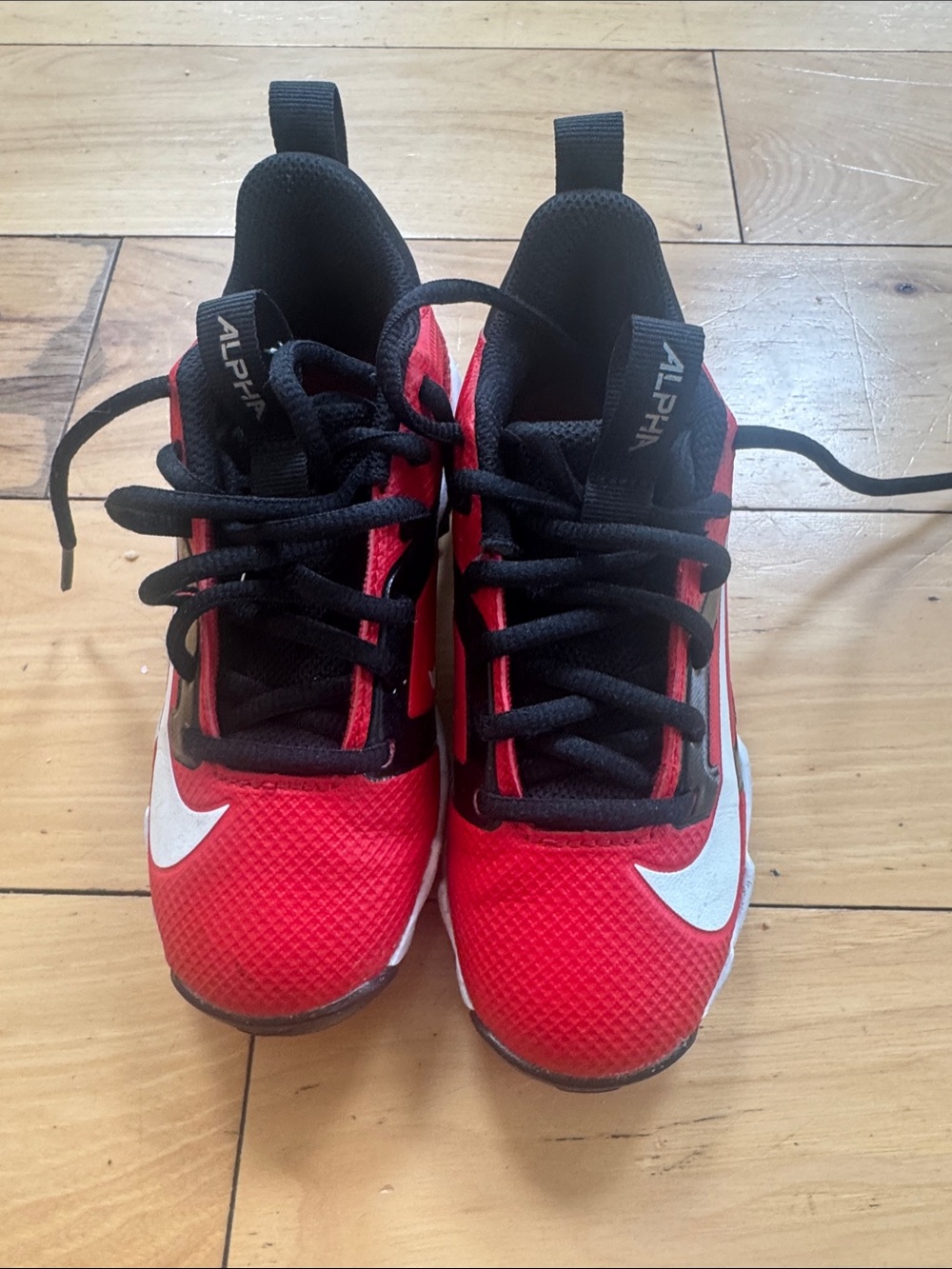 Nike Kids' Red and Black cleats with White Swoosh